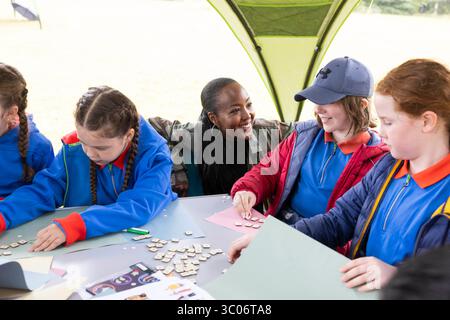 Angellica Bell, die Fernsehmoderatorin und neu ernannte Girlguiding-Botschafterin, erkundet Themen, die für das neue My Views Badge mit Guides (Namen nicht angegeben) in Topstones, Leicestershire, von Interesse sind, um die Einführung von 72 neuen Interessenabzeichen zu markieren, die Mädchen in der gesamten Jugendorganisation zur Verfügung stehen. Ausgabedatum: Montag, 21. Juli 2025. Stockfoto