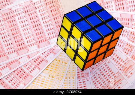 Glücksspiele, bunte Würfel, die über Lottoscheine in die Luft geworfen werden, sucht nach Zahlenspielen und Lotterien Stockfoto
