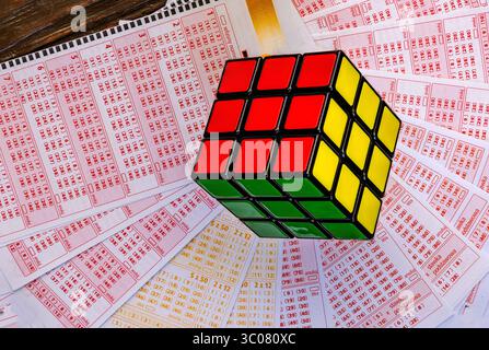 Glücksspiele, bunte Würfel, die über Lottoscheine in die Luft geworfen werden, sucht nach Zahlenspielen und Lotterien Stockfoto