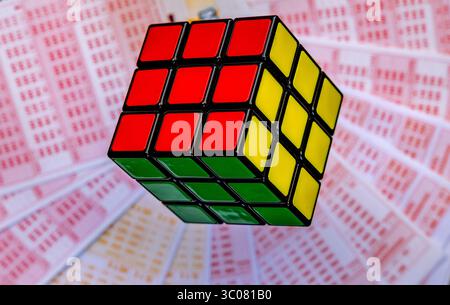 Glücksspiele, bunte Würfel, die über Lottoscheine in die Luft geworfen werden, sucht nach Zahlenspielen und Lotterien Stockfoto