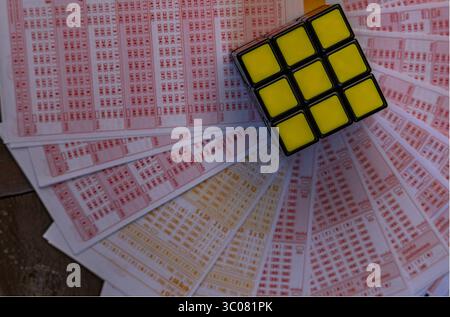 Glücksspiele, bunte Würfel, die über Lottoscheine in die Luft geworfen werden, sucht nach Zahlenspielen und Lotterien Stockfoto