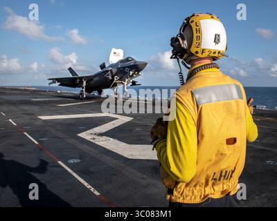 1. September 2018 - Indischer Ozean - Aviation Boatswains Mate (Handling) Airman Daigan Bishop signalisiert eine F-35B Lightning II, die der Avengers of Marine Fighter Attack Squadron (VMFA) 211 zugeordnet ist, als sie vom Flugdeck des amphibischen Angriffsschiffs USS Essex (LHD 2) während eines geplanten Einsatzes der Essex Amphibious Ready Group (ARG) und der 13th Marine Expeditionary Unit (MEU) startet. Die Essex ARG/13th MEU ist ein tödliches, flexibles und beharrliches Navy-Marine-Corps-Team, das im Einsatzgebiet der 5. US-Flotte eingesetzt wird, um Marineoperationen zu unterstützen, um die Stabilität der Seefahrt zu gewährleisten Stockfoto