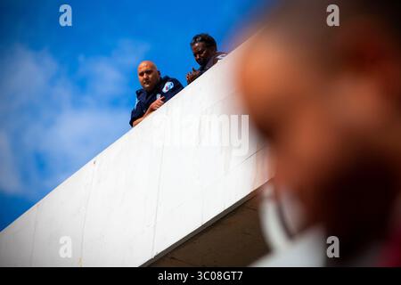 13. Oktober 2018 – Richmond, Virginia, USA – zwei Polizeibeamte aus Richmond beobachten den National Marsch für Gerechtigkeit und Reformation aus der obersten Etage des Hauptquartiers des Richmond Police Department. Berichte über einen nicht identifizierten Polizisten, die von Mitgliedern der ACLU und Demonstranten gesehen wurden, sollen den marsch aus der Garage der Polizei im dritten Stock von Richmond auf Videoband übertragen haben. (Kreditbild: © John C. Clark via ZUMA Wire) Stockfoto