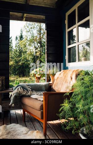 Gemütliche skandinavische Veranda mit Blick auf den ruhigen Wald in schweden Stockfoto
