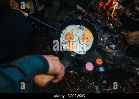 Camper kochen Spiegeleier am brennenden Lagerfeuer in Hotagen, schweden Stockfoto