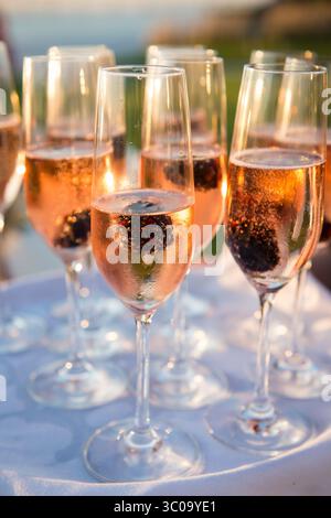 Gekühlter Rosé-Champagner mit Brombeeren beim Empfang bei Sonnenuntergang Stockfoto