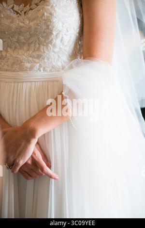 Nahaufnahme von Bride's Hands und Perlenbesatz Hochzeitskleid Stockfoto