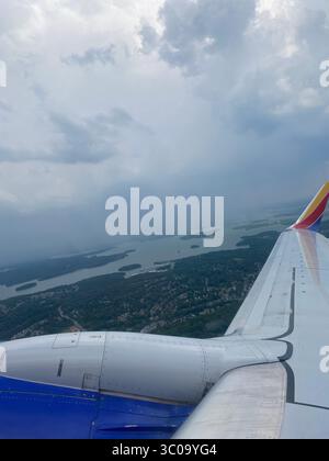 Blick aus dem Flugzeugfenster auf dem Weg nach Los Angeles mit Wolken, Flügeln und Landschaft darunter; fotografiert von Five Points Einheimischen. Stockfoto
