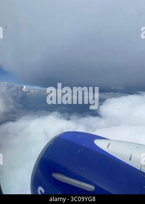 Blick aus dem Flugzeugfenster auf dem Weg nach Los Angeles mit Wolken, Flügeln und Landschaft darunter; fotografiert von Five Points Einheimischen. Stockfoto