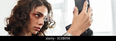 Eine Frau mit lockigen Haaren konzentriert sich auf ihre Kamera, eingetaucht in kreative freiberufliche Arbeit zu Hause, Banner Stockfoto