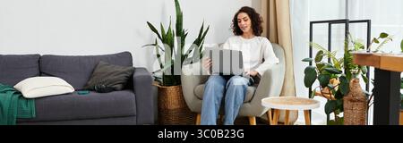 Eine junge Frau mit lockigen Haaren konzentriert sich auf ihren Laptop, während sie ihren entfernten Arbeitsplatz, Banner, genießt Stockfoto
