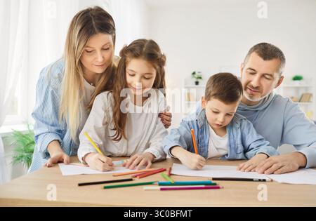 Liebevolles FamilienHobby, Mutter, Vater zu Hause haben Spaß beim Malen mit niedlichen Kindern zusammen in Album Stockfoto