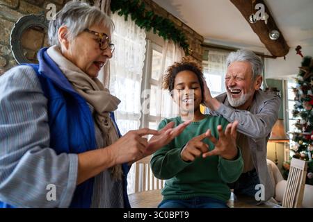 Herzzerwärmende Familie, die Zeit zusammen genießt, glückliches schwarzes Mädchen, das mit ihren verschiedenen Großeltern glücklich ist Stockfoto