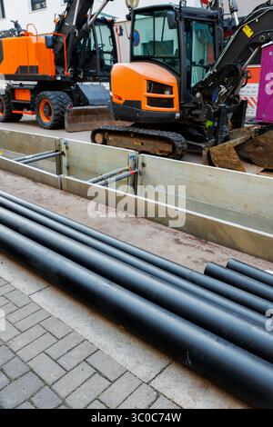 Neue moderne, isolierte städtische Rohrleitungsbaustelle freiliegende unterirdische Rohre in Unterwassergräben. Isolierte Stahlrohre liegen an Stockfoto