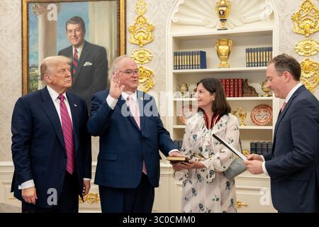 Präsident Donald Trump sieht zu, wie Billy Long offiziell als Internal Revenue Service Commissioner von EPA-Administrator Lee Zeldin im Oval Office des Weißen Hauses am 18. Juli 2025 vereidigt wird. An der Zeremonie nahmen Familienmitglieder und Beamte Teil. Im Hintergrund ist ein Porträt von Präsident Ronald Reagan zu sehen. Bild mit freundlicher Genehmigung des Weißen Hauses. Stockfoto