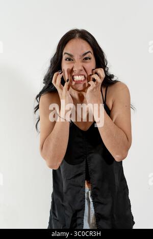 Die junge Frau ist wütend und frustriert, zeigt Zähne und Nägel Stockfoto