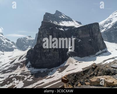 Blick auf einen dramatischen, schneebedeckten Bergrücken mit steilen Felsklippen im Banff National Park, Alberta, Kanada. Raues alpines Gelände mit lockerem Felsen Stockfoto