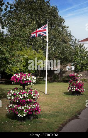Union-Flagge in der Mitte des Dorfes mit Blumenschmuck Stockfoto