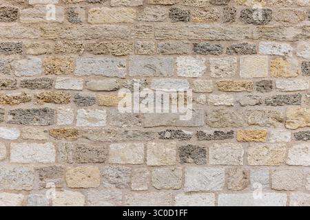 Nahaufnahme einer natürlichen Wandstruktur aus Muschelstein, ideal für Design, Architektur und Hintergrund. Mit detaillierten und rustikalen Tönen, Stockfoto