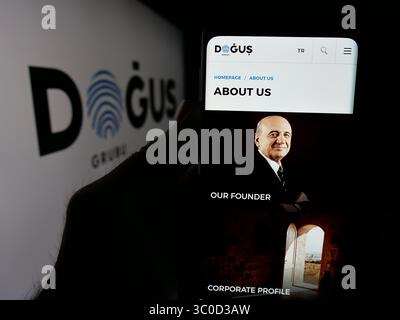 Stuttgart, Deutschland - 16.05.2025: Person mit Smartphone und Webseite des türkischen Unternehmens Dogus Holding A.S. auf dem Bildschirm vor dem Logo. Stockfoto