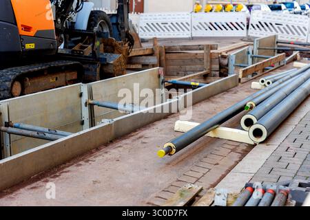 Neue moderne, isolierte städtische Rohrleitungsbaustelle freiliegende unterirdische Rohre in Unterwassergräben. Isolierte Stahlrohre liegen an Stockfoto