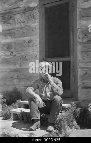 August 2018 - Montana, USA - Cowboy Rauchen vor Bunkhouse, Quarter Circle U Ranch, Big Horn County, Montana, USA, Arthur Rothstein, Farm Security Administration, Juni 1939 (Kreditbild: © JT Vintage/Glasshouse Via ZUMA Wire) Stockfoto