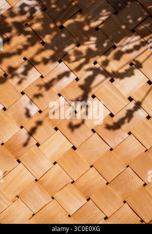 Aus Bambus gewebter Strohkorb mit tropischem Farbüberzug. Sommerstrand im ästhetischen Hintergrund. Minimales Outdoor-Design aus natürlichem Rattan. Stockfoto