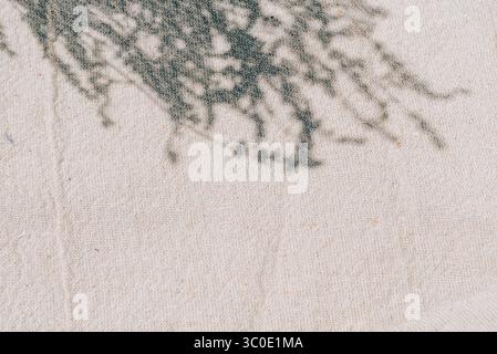 Beigefarbenes Leinen aus natürlicher Baumwolle mit Lavendelschatten und Sonnenlicht-Textur. Minimaler ästhetischer Sommer-Hintergrund für Schönheit und Spa-Mockup-Vorlage mit Empt Stockfoto