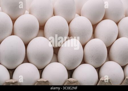 Hühnereier mit Eierschale in einer Kartonverpackung. Haufen Hühnereier aus dem Dorf. Leckeres Frühstück. Eier auf der Theke. Stockfoto
