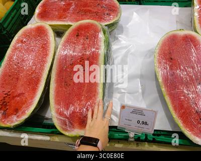 Heraklion, Kreta, Griechenland – 20. August 2024: Große halbe Wassermelonen von Akrotiri im Supermarkt erhältlich, 0,98 €/kg, handgezeichnet für Skala. Stockfoto