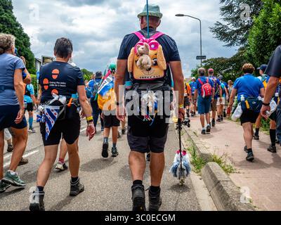 Nijmegen, Gelderland, Niederlande. Juli 2025. Ein Teilnehmer sah, wie er mit einem Spielzeughund ging. Die International Four Days Marches (auf Niederländisch „de Vierdaagse“) sind die weltweit größte mehrtägige Wanderveranstaltung mit rund 47,000 Teilnehmern (Credit Image: © Ana Fernandez/SOPA images via ZUMA Press Wire). Nicht für kommerzielle ZWECKE! Stockfoto