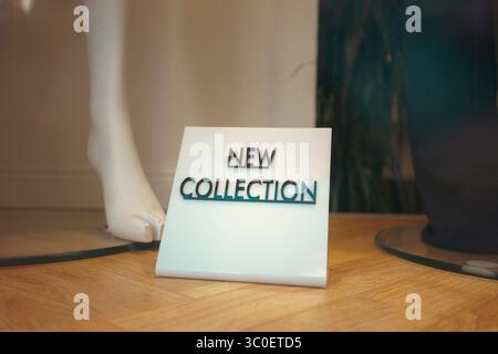 Eine neue Kollektion als Benachrichtigung im Fenster eines Modegeschäfts. Stockfoto