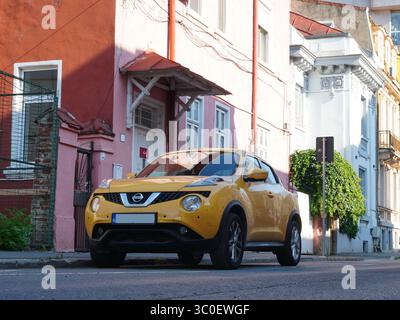 Bukarest, Rumänien – 20. Juli 2025: Vorderansicht des gelben Autos von Nissan Juke, das auf einer Straße mit schönen alten Häusern in der Stadt geparkt ist Stockfoto