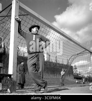 1950s Fußball. Ein Torwart, der am Torrahmen hängt und das Spiel anschaut, das wahrscheinlich in den anderen Teams auf der Hälfte des Feldes spielt. Höchstwahrscheinlich ein Amateur-Fußballspiel, da er seltsamerweise einen Hut trägt, tun Torhüter selten. Er hat die Nummer eins auf seinem Sweatshirt. Schweden 1952 Stockfoto