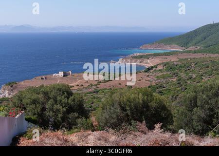 Die ruhige Küstenlandschaft zeigt die Meerenge von gibraltar, mit einem verlassenen Gebäude, trockener Vegetation und üppigem Grün, die das Be hervorheben Stockfoto