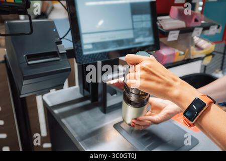 Weibliche Kassiererin, die Lebensmittel an der Kasse im Supermarkt einscannt, mit Barcode-Scanner und Computer Stockfoto