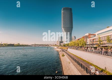 1. Juni 2025, Belgrad, Serbien: Menschen, die an einem sonnigen Tag entlang der Uferpromenade spazieren, mit malerischem Blick auf den Kula-Turm und den Fluss Save Stockfoto