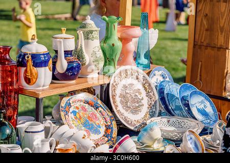 1. Juni 2025, Belgrad, Serbien: Bunte Tassen aus Vintage Porzellan, Teller, Teekannen und Vasen auf einem Holzstand auf einem Flohmarkt Stockfoto