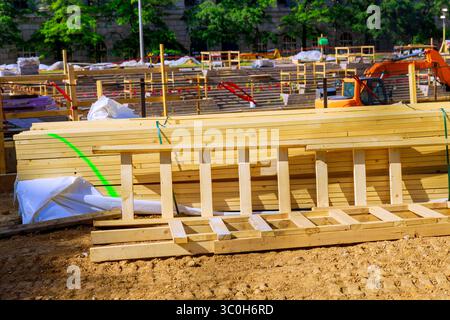 Holzstapel sind ordentlich auf der Baustelle angeordnet, mit Maschinenhintergrund im Werksbereich Stockfoto