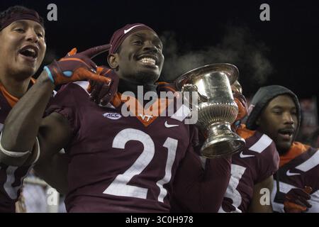 23. November 2018: Blacksburg, Virginia, USA – Virginia Tech Hokies Defensivverteidiger Reggie Floyd (21) hält den Commonwealth Cup nach dem Sieg gegen die Virginia Cavaliers am 23. November 2018. (Kreditbild: © Greg Atkins/ZUMA Wire) Stockfoto