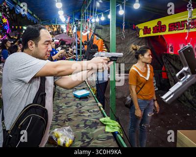 24. November 2018: Bangkok, Bangkok, Thailand: Ein Mann schießt auf einem Schießstand auf der Roten Kreuzmesse mit einer B.B.-Pistole auf ein Ziel. Die Rote Kreuz-Messe ist eine Spendenaktion und jährliche Veranstaltung in Bangkok, die jeden Abend Tausende von Besuchern anzieht. Die Messe bietet Glücksspiele, eine halbe Strecke mit Fahrgeschäften, Kunsthandwerk und Essen. Dies ist das erste Jahr, in dem die Messe im Lumpini Park stattfindet. Zuvor war es in der Dusit-Sektion von Bangkok. Die Messe 2018 markiert 125 Jahre Dienst für das Rote Kreuz in Thailand. (Bild: © Sean Edison/ZUMA Wire) Stockfoto
