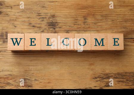 Word Welcome aus Holzwürfeln auf dem Tisch, Blick von oben Stockfoto
