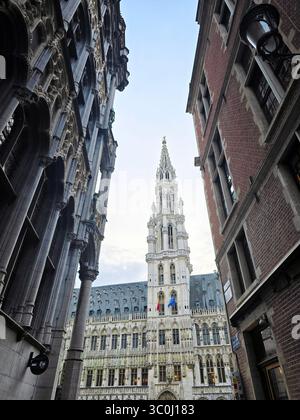 Gerahmter Blick auf den Turm des Brüsseler Rathauses zwischen zwei historischen Gebäuden im Stadtzentrum. Stockfoto