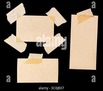 Set aus einer Vielzahl von leeren braunen Papierstücken, die mit Abdeckband isoliert auf schwarzem Hintergrund befestigt sind Stockfoto