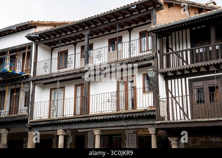 Dieses Bild zeigt die wunderschön gefertigten Holzbalkone und die komplizierten schmiedeeisernen Geländer der traditionellen spanischen Architektur. Weiß getüncht Stockfoto