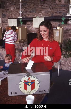 Die weibliche Wählerin legt ihren abgegebenen Wahlzettel am Wahltag in eine verschlossene Wahlurne. ©Bob Daemmrich Stockfoto