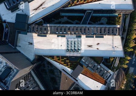Luftdrohnenfoto von umweltfreundlichen riesigen Dach-Solarpaneelen mit sauberer erneuerbarer Solarenergie, die auf einem Dach eines großen Geschäftsgebäudes installiert sind Stockfoto