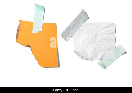 Verbranntes orangefarbenes Papier und weißes zerknittertes Papier auf Klebeband isoliert auf weißem Hintergrund. Kopierbereich Stockfoto
