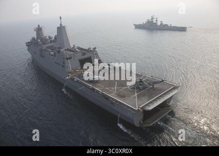 26. Dezember 2018 - USS Anchorage, Indischer Ozean - das amphibische Transportschiff USS Anchorage der San Antonio-Klasse fährt mit einem UH-3H-Hubschrauber der Indischen Marine auf dem Landedeck während kooperativer Übungen mit dem Zerstörer der Indischen Marine IN Rajput, rechts, 26. Dezember 2018 im Indischen Ozean. (Bild: © Sgt. Austin Mealy Via ZUMA Wire) Stockfoto