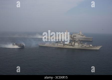 26. Dezember 2018: USS Anchorage, Indischer Ozean - Ein Landungsschiff der US Navy, Luftkissenmanöver an der Seite des Zerstörers der indischen Marine INS Rajput, Bottom, Segeln zusammen mit dem Amphibien-Transportschiff USS Anchorage, TOP, während kooperativer Übungen am 26. Dezember 2018 im Indischen Ozean. (Bild: © Austin Mealy via ZUMA Wire) Stockfoto